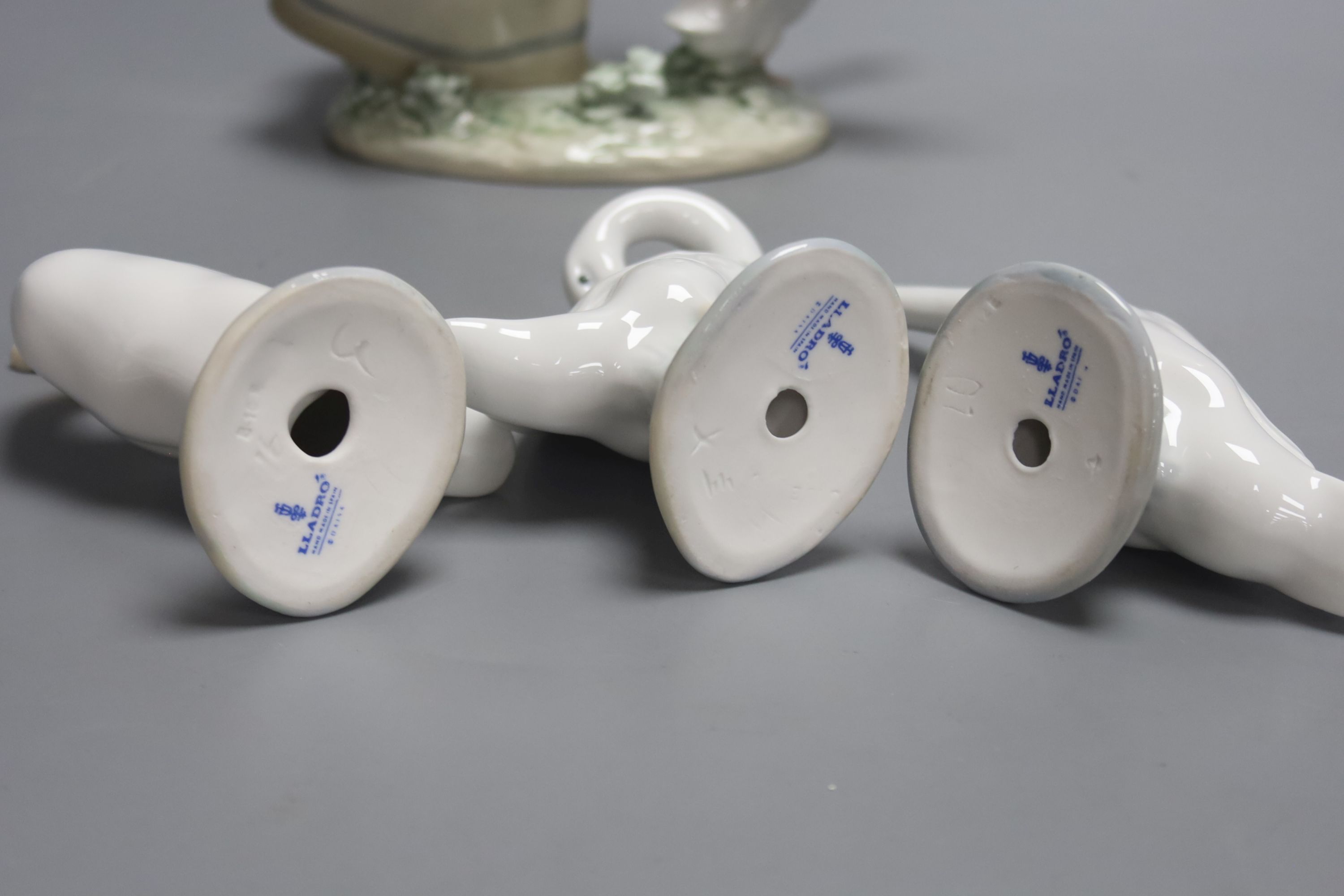 A Lladro figure of a girl with a goose and three single geese models